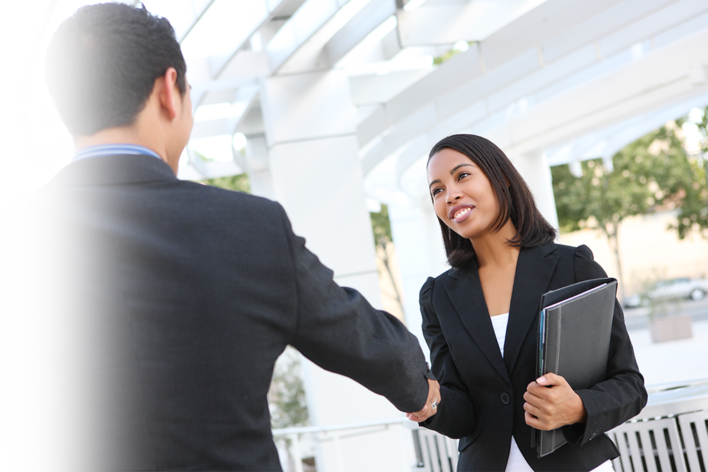 business woman shaking man's hand